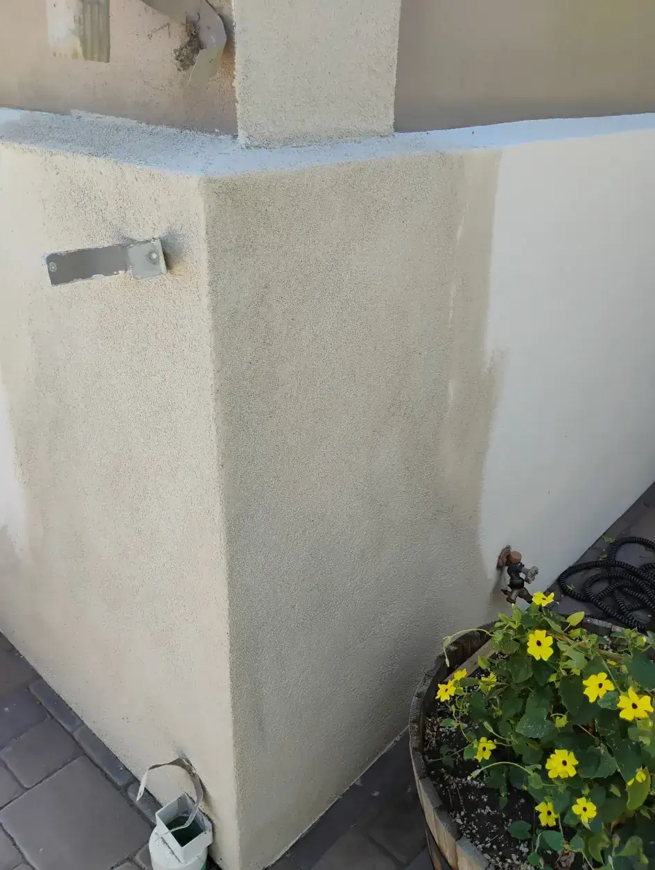 Completed tan finish-coat stucco wall corner beside a flower planter in Reno, NV
