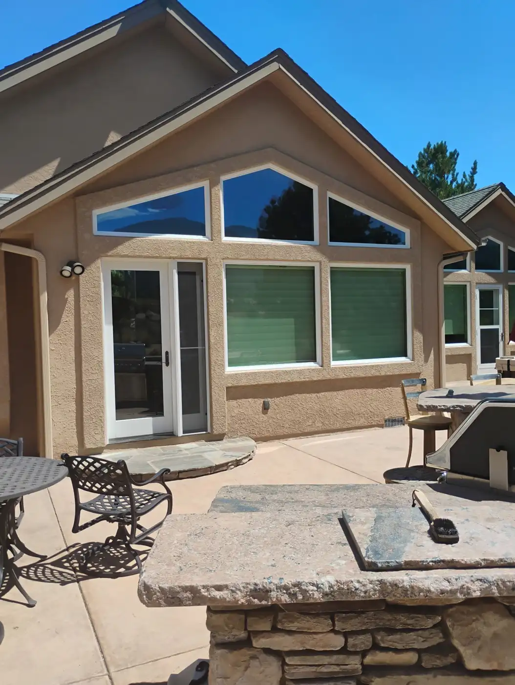 Finished tan stucco home exterior with large windows and stone patio in Reno, NV