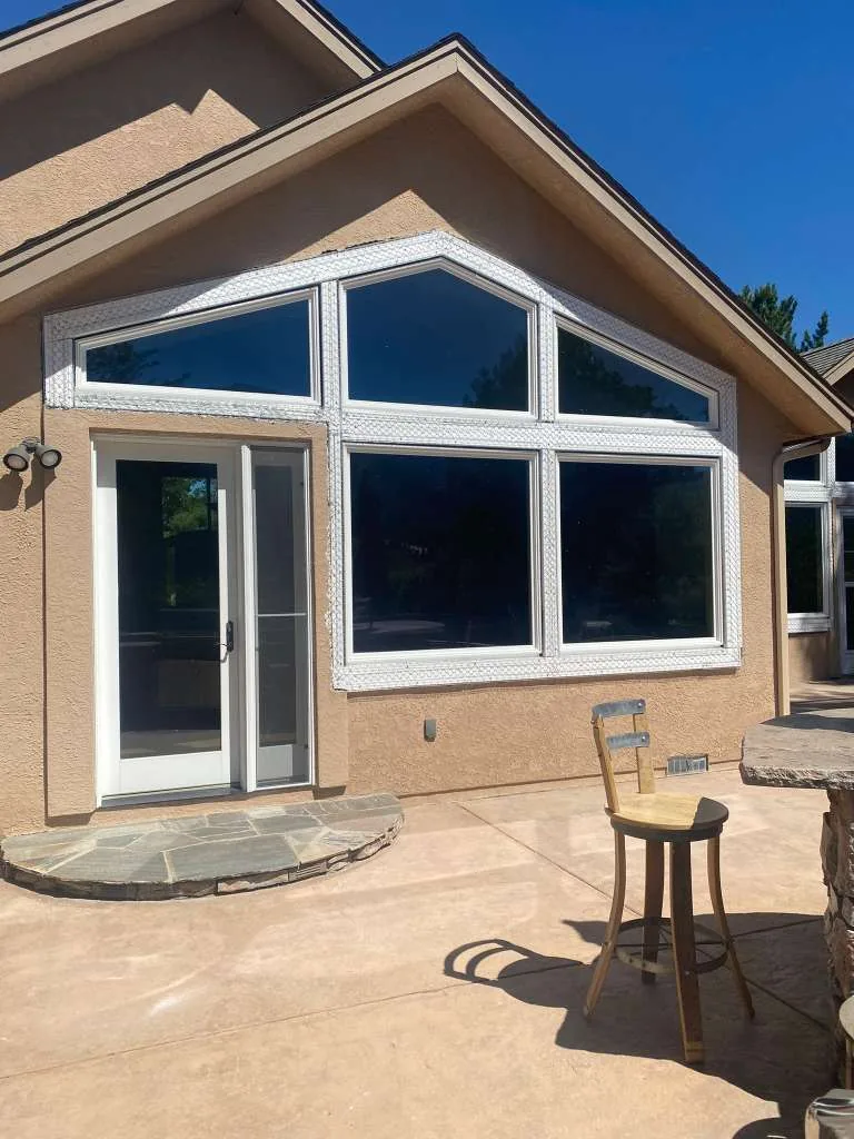 Finished tan stucco gable wall with large windows and flagstone patio in Reno, NV