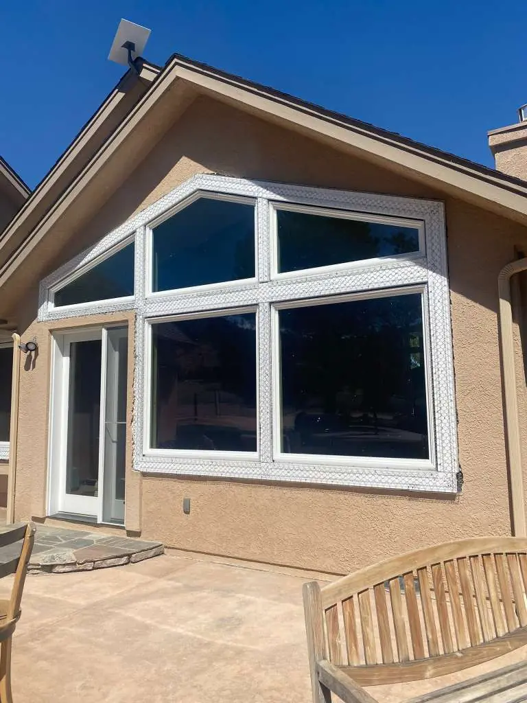 Tan stucco home exterior with new windows and patio under blue sky in Reno, NV