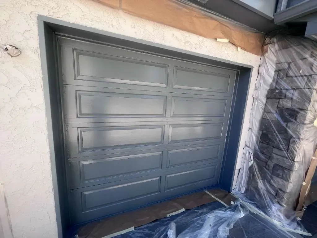 Freshly painted gray garage door framed by stucco and stone in Reno, NV